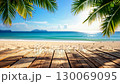 Wooden planks under palm trees overlooking a beautiful tropical beach with turquoise water. 130069095