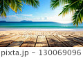 Wooden planks under palm trees overlooking a beautiful tropical beach with turquoise water. 130069096