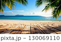 Wooden planks under palm trees overlooking a beautiful tropical beach with turquoise water. 130069110
