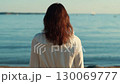 Woman observing calm ocean at sunrise 130069777