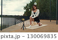 Fitness instructor stretching legs on a terrace 130069835