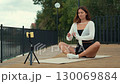 Yoga instructor streaming online class outdoors 130069884