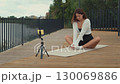 Yoga instructor streaming online class outdoors 130069886