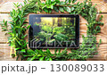 Green leaves frame a tablet with a sustainable development goals interface 130089033