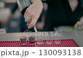Bartender pouring vodka into shot glasses at the bar. 130093138