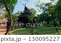Traditional wooden Triangle House or Tri Phum surrounded by lush greenery and trees in the grounds of Baan Dam Museum in Chiang ra, Thailand 130095227