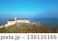 Witness the stunning autumn sunrise illuminating Bezdez Medieval Castle, standing majestically on a hilltop amidst colorful foliage in Czechia's serene landscape. 130110166