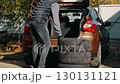 Man loading car tires into trunk for seasonal change 130131121