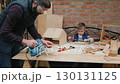 Father and son woodworking project in workshop 130131125