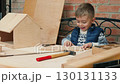 Child learning woodworking with birdhouse project 130131133