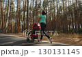 Jogging mother with stroller in forest 130131145