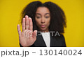 Serious woman making stop gesture with hand 130140024