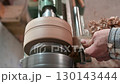 Turnery of a wooden bowl with spiral sawdust shavings with hand and chisel 130143444