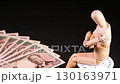 一個坐在椅子上的木偶和一張旋轉的 10,000 日元鈔票 130163971
