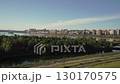 City landscape view with river and greenery under clear blue sky 130170575
