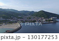 A sweeping aerial view of Nagahama Beach in Atami, Shizuoka, framed by forested mountains and a coastal townscape. 130177253
