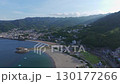 A late afternoon aerial view of Nagahama Beach and surrounding town, with soft shadows and mountain ridges. 130177266