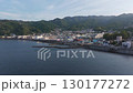 A serene aerial view of Nagahama in Atami, Japan, showing the coastal townscape, harbor, and surrounding mountains at dusk. 130177272