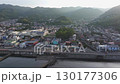 Aerial view of a quiet residential neighborhood in Nagahama Beach, Atami, surrounded by forested mountains under soft evening light. 130177306