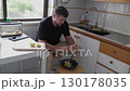 Man peeling potatoes in kitchen 130178035