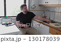 Man washing potatoes in kitchen sink 130178039