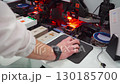 Robotic machine for installing chips, semiconductor transistors on microcircuit, board. Close-up of hands of worker, specialist controlling high-tech machine for production of microcircuits. 130185700
