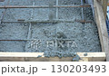 Concrete being poured onto rebar foundation at construction site 130203493