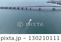 Drone aerial shot of a motorboat passing under Lake Biwa Bridge under a summer sky and the vast expanse of Lake Biwa 130210111