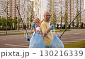 A smile man and a young girl stand in a park in the city, carrying bags filled with the waste they have just collected. They are advocating for the idea of preserving the environment and recycling. 130216339