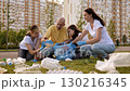 A group of volunteer activists wearing gloves and carrying garbage bags collect plastic waste in the city to protect the environment. They are promoting the concept of recycling. 130216345