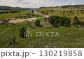 Exploring vast green landscapes and winding roads under bright sky 130219858