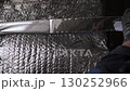 Worker applying foil tape on insulation material seam 130252966