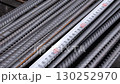 Measuring steel reinforcement bars with tape measure at construction site 130252970