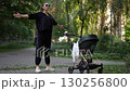 A Mother Enjoying a Beautiful Day Out with Her Baby Stroller in a Lovely Park Environment 130256800