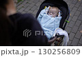A Peaceful Baby Snuggled in a Stroller Enjoying the Fresh Outdoors on a Beautiful Day 130256809