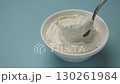 Bowl of cream cheese with spoon, blue background with copy space 130261984