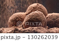 Sweet truffles, round chocolate candies with falling cocoa powder, 4K 130262039