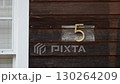 The number 5 on a rustic wood wall of a charming house showcases appealing aesthetics 130264209