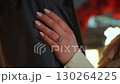 An Elegant Hand Displaying a Ring on a Beautiful Dark Fabric Background for Added Contrast 130264225