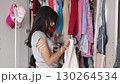 Teen Girl Organizing Clothes in Her Closet 130264534