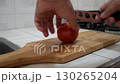 Dicing Tomato on Cutting Board, Hand Cutting Fresh Tomato, Preparing Vegetables for Meal 130265204
