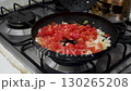 Frying Tomato and Onion in Pan, Cooking Vegetables on Stove for Scrambled Eggs, Sauteing Onion with Tomato in Frying Pan 130265208