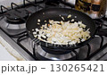 Frying Onion and Tomato in Pan, Cooking Onion with Tomato on Stove, Sauteing Vegetables in Frying Pan 130265421