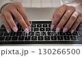 Close up of female hands typing on laptop keyboard at desk 130266500