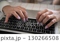 woman hands typing on laptop keyboard at home office close up front view 130266508
