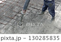 Pouring ready-mixed concrete over steel reinforcement to create house.  130285835