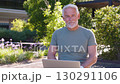 Senior businessman using laptop and smiling at 130291106