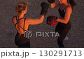 Female fighters practicing defence boxing on sandy 130291713