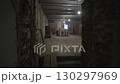 View through corridor with peeling walls reveals brick room 130297969