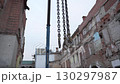 Hooks hang motionless against backdrop of fragile bricks 130297987